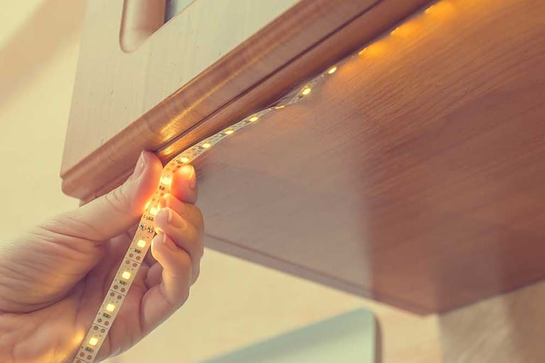 Installing LED strip lights along a cabinet edge