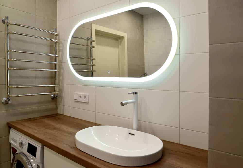 A bathroom mirror surrounded by an LED strip