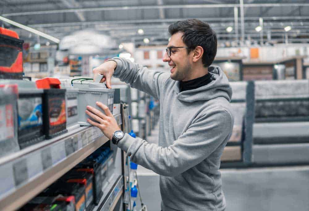 A happy customer buying a battery from a supermarket