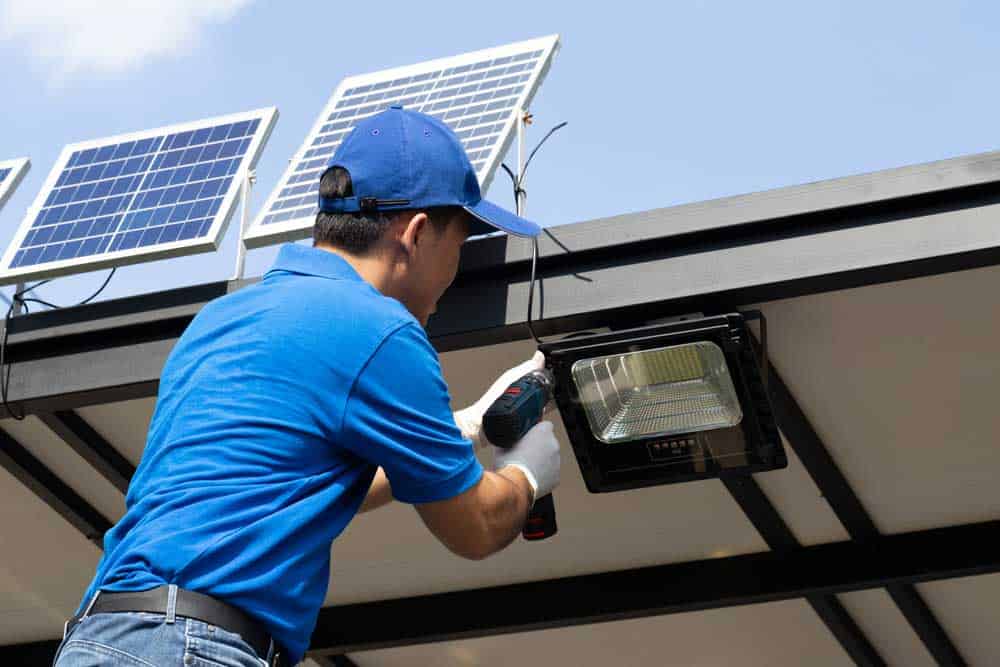 Battery Operated LED Lights:  A technician installs a solar panel to charge a battery pack